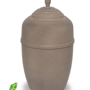 Beige, rundad urna med trappstegsformat lock med en liten skulpterad knopp på toppen. Urnan är placerad på en vit bakgrund med en grön bladlogotyp och ordet "MILJÖURNA" i det nedre vänstra hörnet.